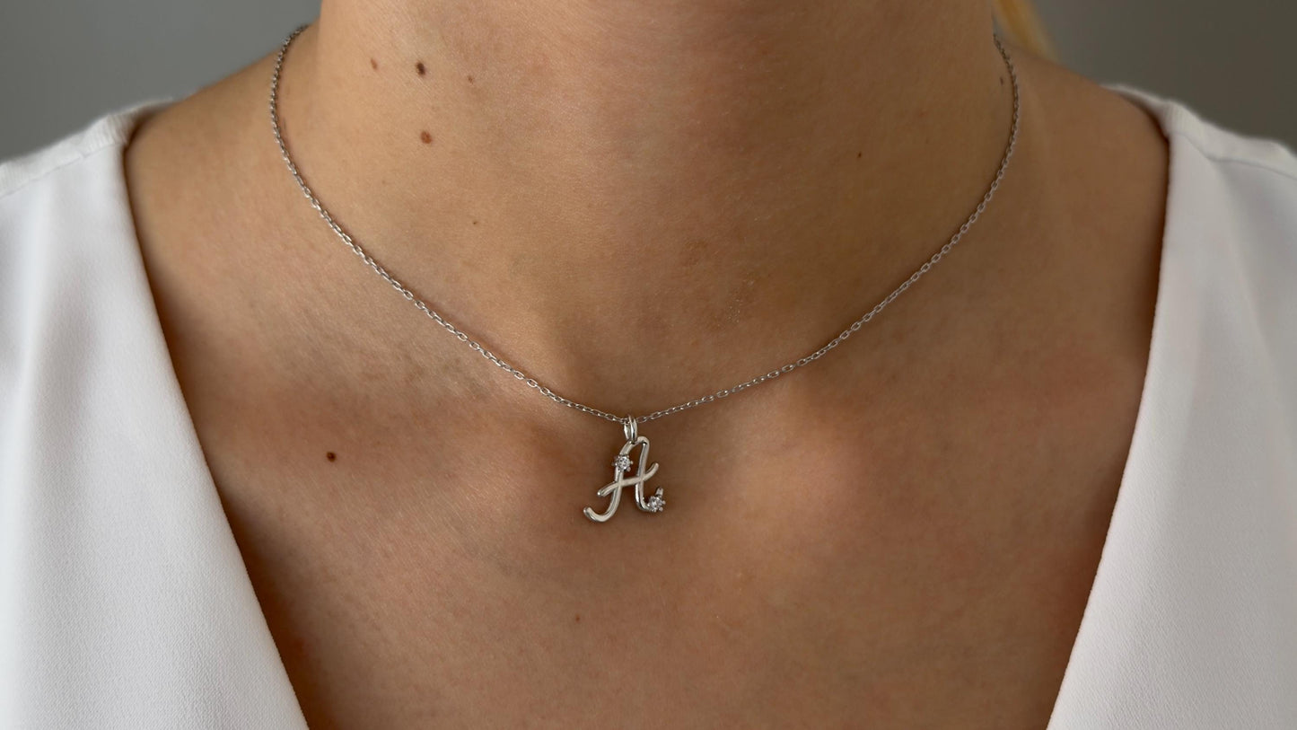 Initial necklace worn on model collarbone