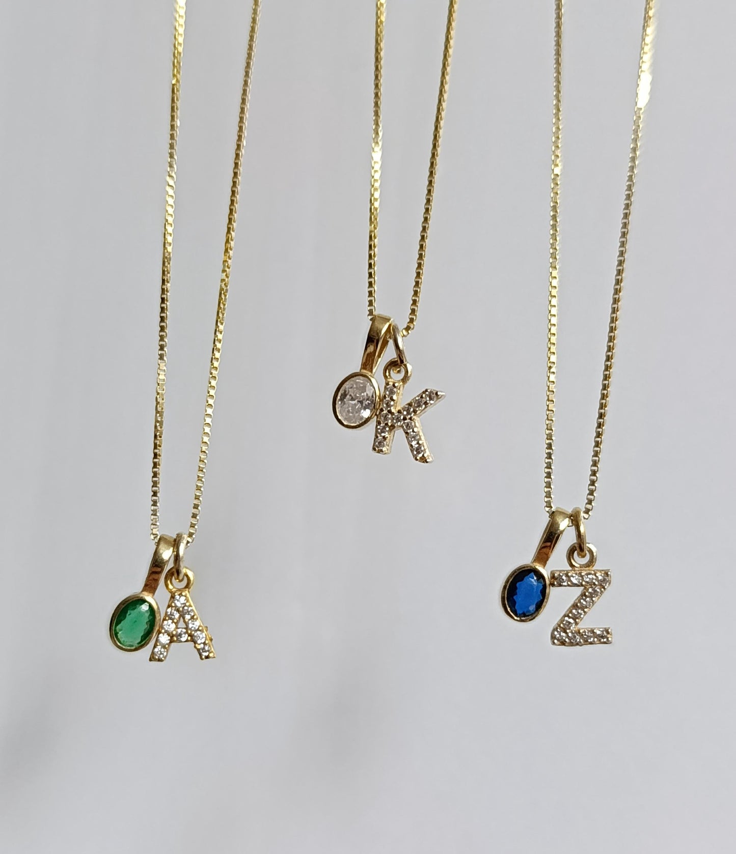 Gold gemstone initial necklace with oval CZ pendant