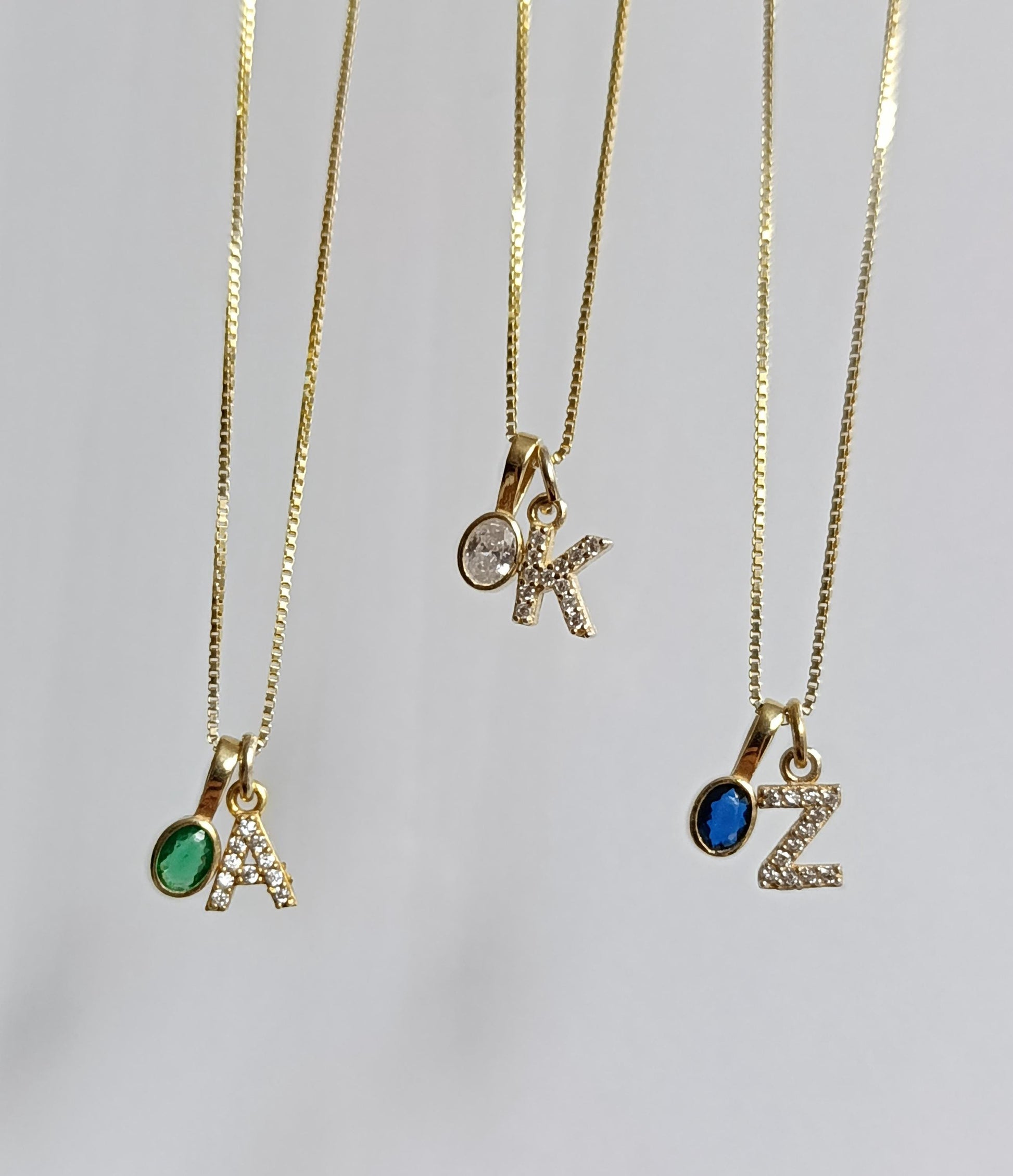 Gold gemstone initial necklace with oval CZ pendant