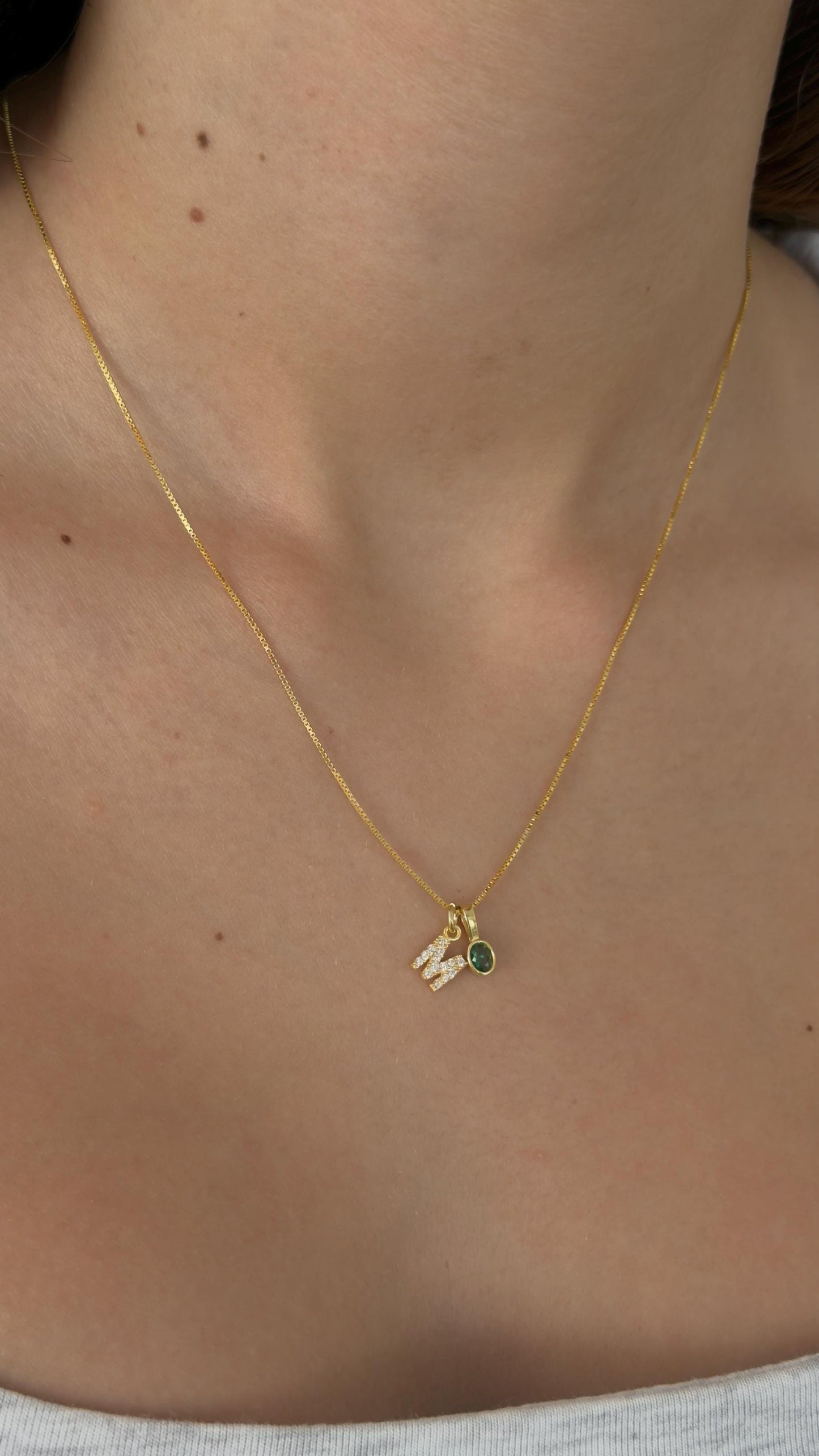 Gold plated letter necklace with green gemstone