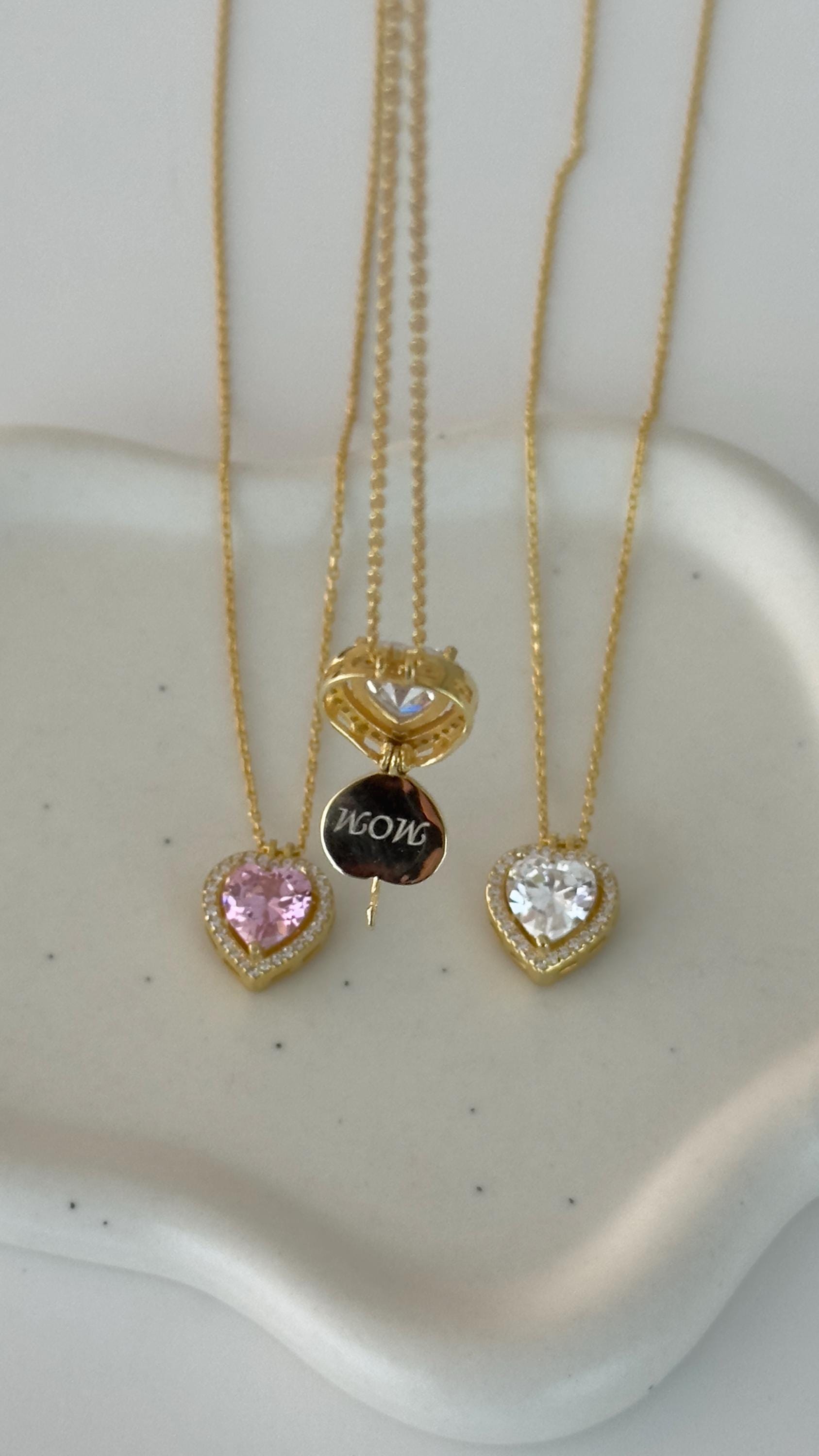 Personalized name necklaces in gold, rose gold, and silver finishes with engraved nameplates