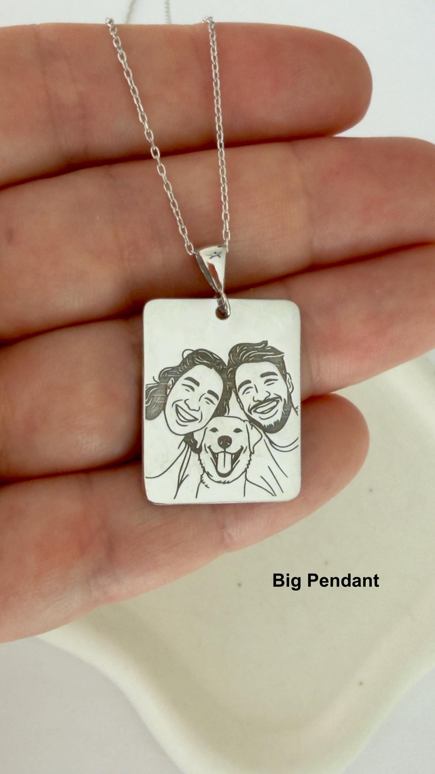 Close-up of engraved portrait necklace in sterling silver.