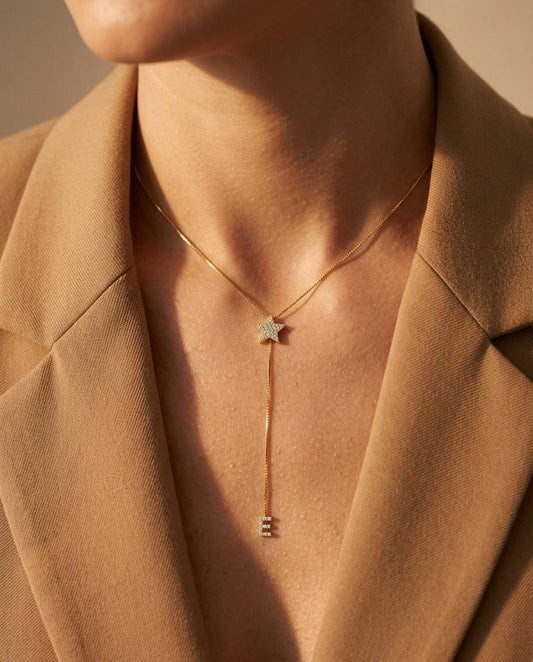 Dainty gold diamond star initial lariat necklace worn on model, featuring pavé star pendant with drop letter charm, elegant minimalist personalized jewelry for women