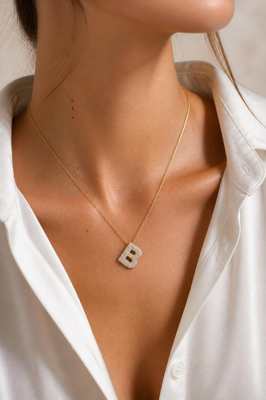 Sterling silver initial necklace with sparkling pavé diamond letter pendant in 14K gold, personalized initial jewelry worn as a dainty necklace.