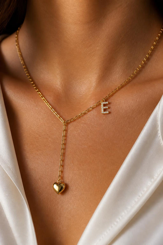 Dainty gold Y necklace with sparkling initial letter and puffy heart drop, personalized lariat necklace shown close up on model.