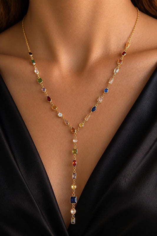Model wearing a lariat drop necklace featuring multicolor rainbow gemstone stations and a long Y-shaped pendant. Dainty 14K gold plated sterling silver necklace, colorful diamond jewelry, elegant layering necklace, birthday gift for her.