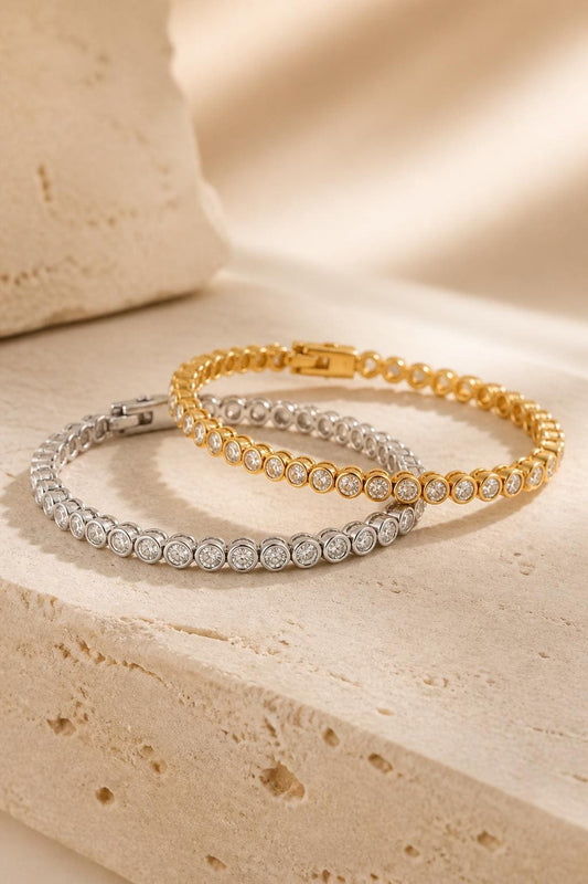 Gold and silver bezel diamond tennis bracelets displayed together, featuring round sparkling stones in an elegant dainty bracelet design.