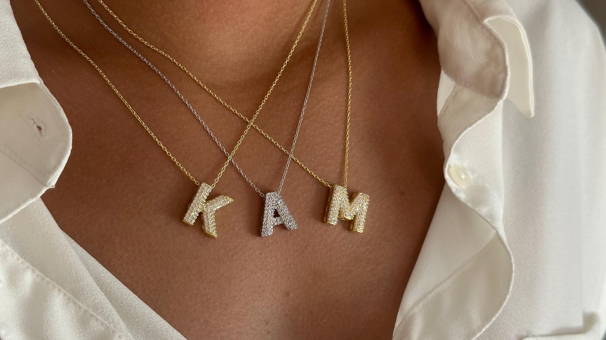 Model wearing gold  silver initial pendant necklaces with sparkling CZ stones, trendy 3D bubble letter design